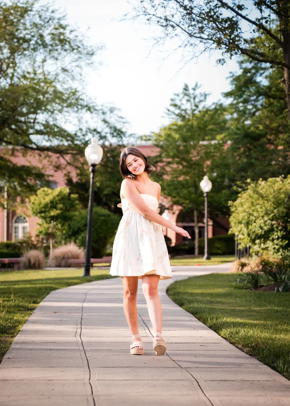 Julia Lebow walking on a tree-lined campus path.