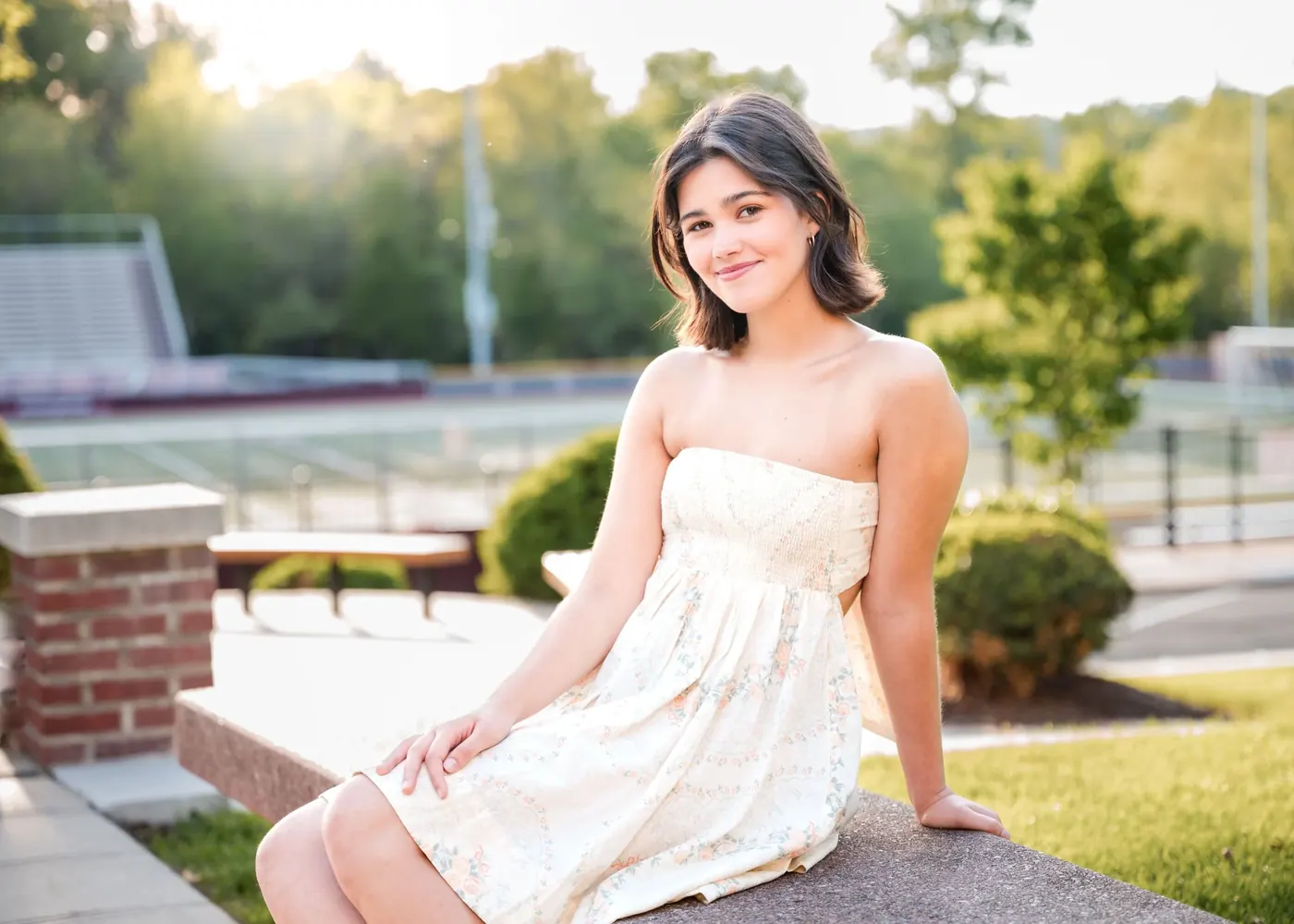 Julia Lebow seated outdoors in a white dress.
