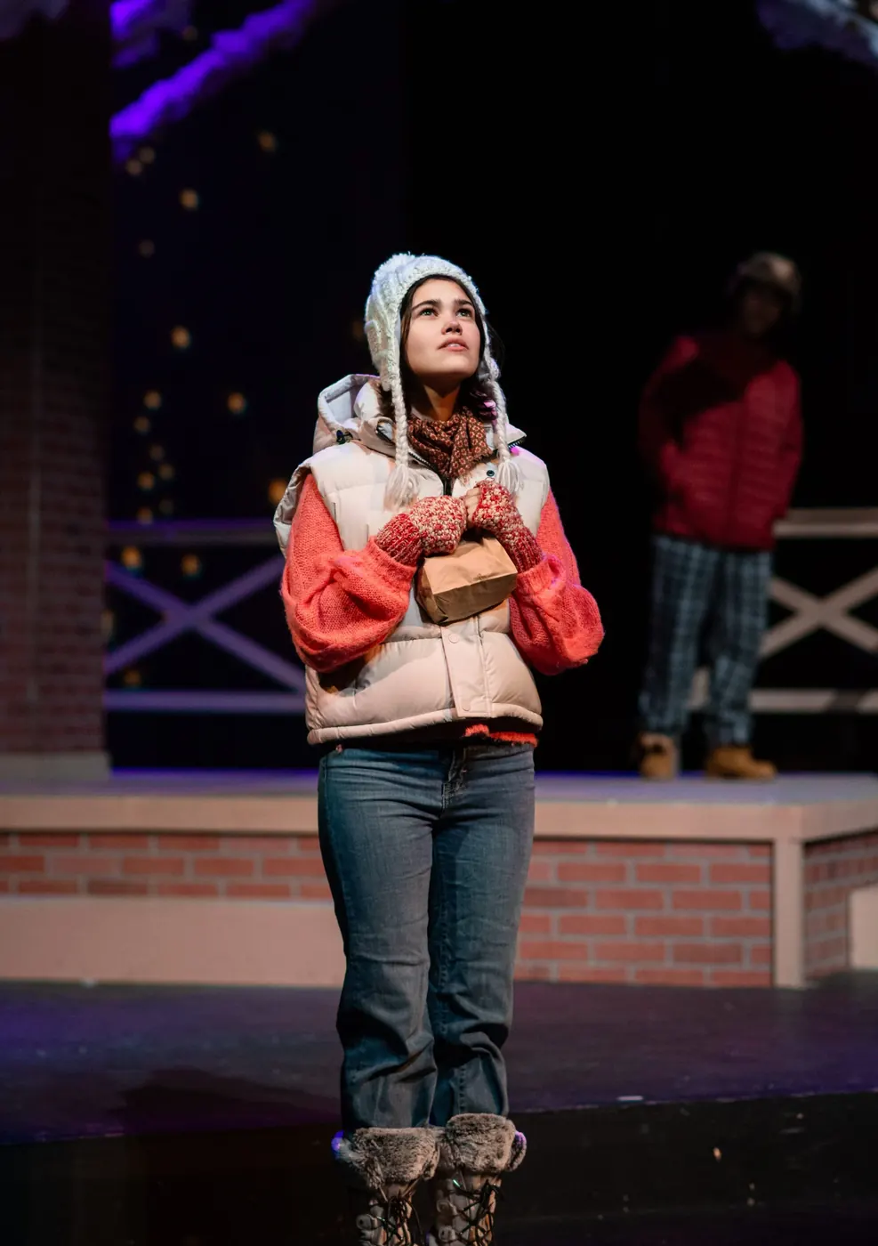 Julia Lebow standing under a spotlight during a stage performance.
